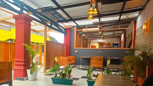 Un espacio interior con suelo de cuadros, muebles de madera y plantas en macetas.