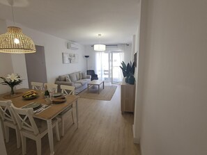 A modern living room with a dining area, a sofa, and a coffee table.