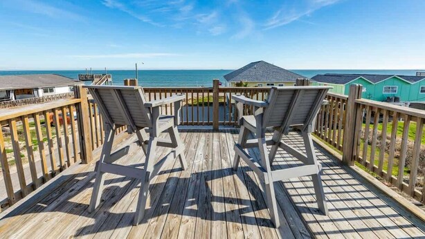 A wooden deck with two chairs facing a view of the ocean. - Pink Pearl - Where Mr Ocean Blue Meets Ms Posh Pink! (Surfside Beach)