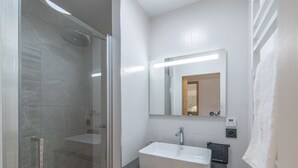 A modern bathroom with a glass-enclosed shower, a white sink, and a mirror above it. - New apartment 108m², center Huez, parking, wifi, 6 guests (Huez)
