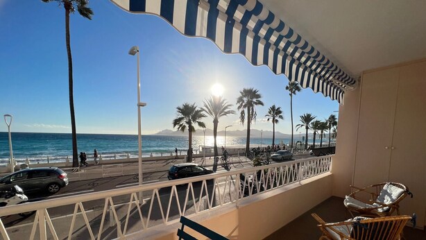 A balcony with a view of the beach, palm trees, and cars on the road. - Shelly luxury sea vew (Cannes)