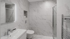 A modern bathroom with a marble floor, a white sink, a toilet, and a glass shower enclosure. - 2BED/2BATH Bliss | Parking - VAT Q - By Tempstay (Berkshire)