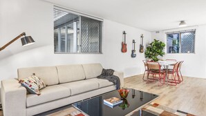 A modern living room with a sofa, coffee table, and dining area. - Vintage Vibes East Freo 2B 1BA (East Fremantle)