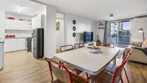 A modern apartment with a kitchen, dining area, and living room. - Vintage Vibes East Freo 2B 1BA (East Fremantle)