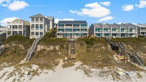 A beachfront hotel with multiple buildings, a sandy beach in the foreground, and a clear sky. - Seamist 7 ~ Beachfront on 30A (Seacrest)