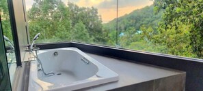 A modern bathroom with a large sink and a view of a lush green landscape through a large window. - AO504 - 1 Bedroom Serviced Apartment Top Floor Forest View with Bathtub Ao Nang (Tambon Ao Nang)