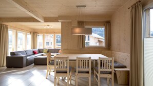 A wooden interior with a dining table, chairs, a sofa, and large windows. - Murau 11 - large terrace & good location (Murau)
