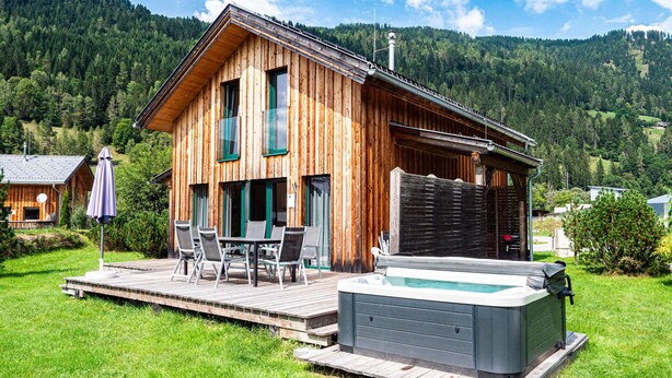 A wooden cabin with a hot tub and outdoor seating area. - Murau 9 - with infrared sauna and whirlpool (Murau)