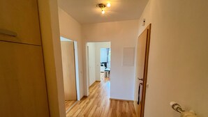 A hallway with wooden flooring leading to a room with a door and a light fixture on the ceiling. - Apartment Ottl 2 - charming and good location (St. Georgen am Kreischberg)