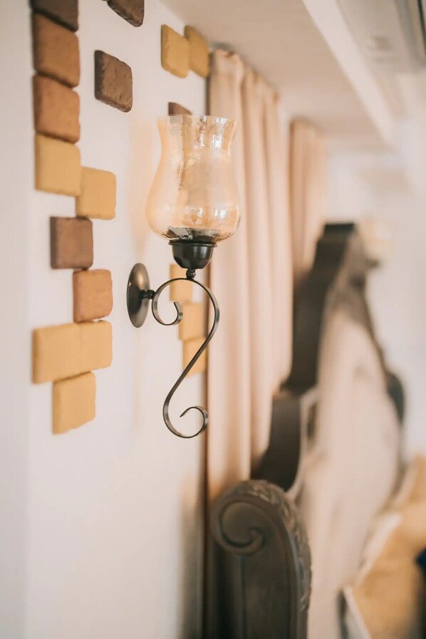 A wall-mounted lamp with a glass shade and a metal base, positioned next to a wall with a brick pattern. - RAINBOW SEA Maeda Hills (Onna)