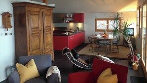 Een gezellige woonkamer met een bank, stoelen en een eethoek met een tafel en stoelen.