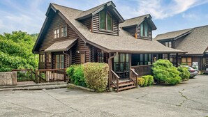 A log cabin-style hotel with a prominent porch, multiple windows, and a well-maintained lawn.