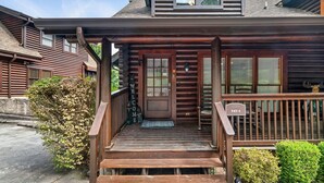 A wooden cabin with a front porch, a door marked "747-1", and a mailbox.