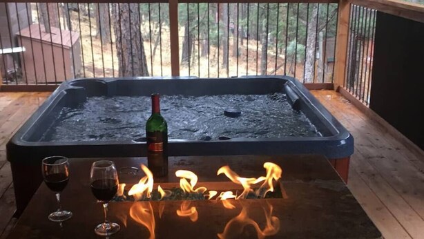 A hot tub with flames on a wooden deck. - SneakAway in the Historic UpperCanyon! (Ruidoso)