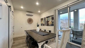 A dining area with a table, chairs, and a view through a glass door.