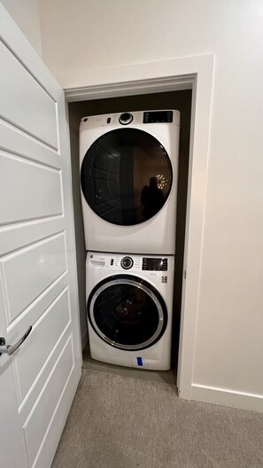 A laundry room with two stacked washing machines. - The Lofts #44 | Townhome Pool Resort (Saint George)
