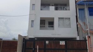 A multi-story building with a flat roof, large windows, and a gated entrance. - Apartment with lake access and jacuzzi in El Peñol, Antioquia (Peñol)