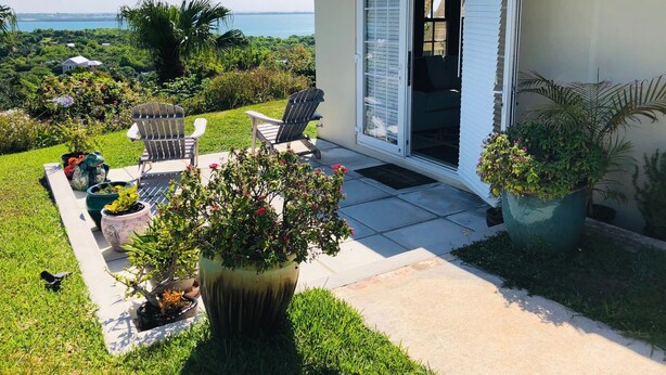 A house with a patio, outdoor seating, and a view of the sea.