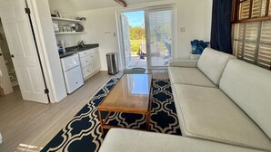 A compact living space with a kitchenette, a sofa, and a dining table.