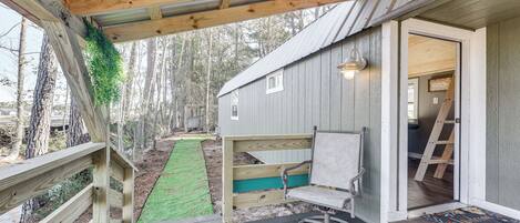 A wooden deck with a bench and a door leading to a building.