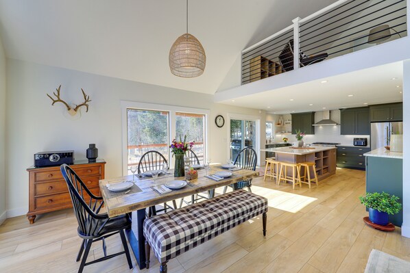 A spacious kitchen with a dining area, wooden flooring, and a loft space above. - Spacious Black Hawk Home w/ Deck & Mountain Views! (Black Hawk)
