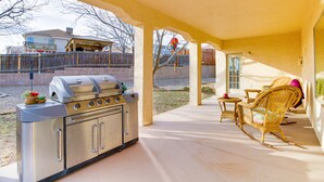 A covered patio with a barbecue grill, wicker furniture, and a view of a house in the background. - Lovely Albuquerque Home w/ Patio, 5 Mi to Old Town (Albuquerque)
