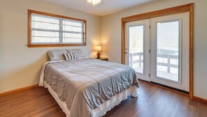 A bedroom with a bed, a ceiling fan, a window with blinds, and a door leading to a balcony. - Pineville Home w/ Fire Pit < Half-mi to Elk River! (Pineville)