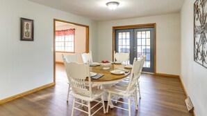 A dining room with a round table, white chairs, and a wooden floor. - Pineville Home w/ Fire Pit < Half-mi to Elk River! (Pineville)