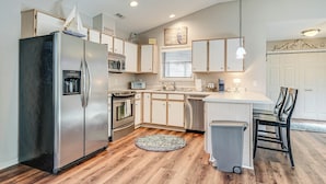 A modern kitchen with stainless steel appliances, wooden cabinets, and a central island. - Northeast Wilmington Home ~ 5 Mi to Beach! (Wilmington)