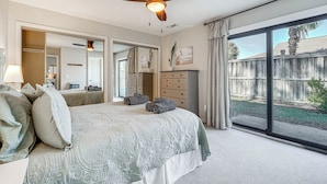 A bedroom with a large bed, a ceiling fan, a dresser, and a sliding glass door to the outside. - Northeast Wilmington Home ~ 5 Mi to Beach! (Wilmington)