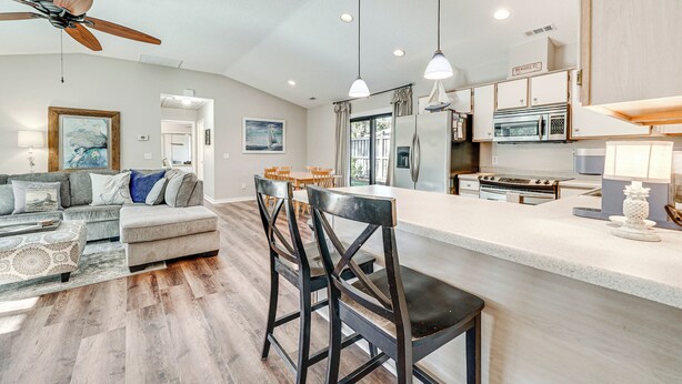 A modern kitchen with a central island, built-in appliances, and a dining area with a sofa and chairs. - Northeast Wilmington Home ~ 5 Mi to Beach! (Wilmington)
