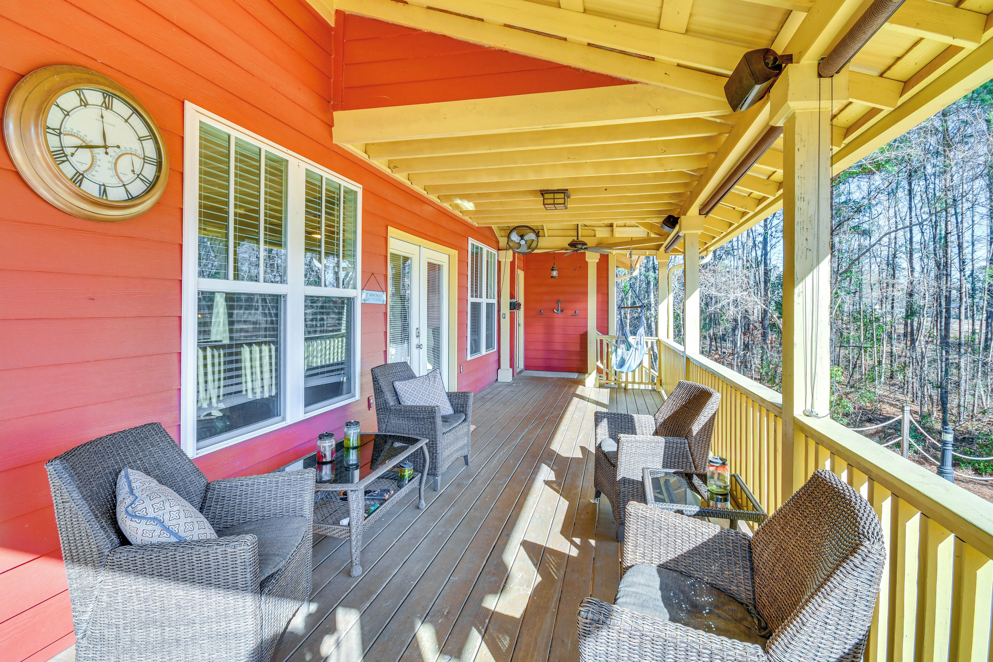 A covered porch with wicker furniture and a clock on the wall.