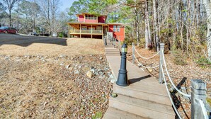 A two-story building with a porch and a wooden deck leading to it. - Lakefront Jacksons Gap Retreat w/ Grill & Dock! (Jacksons' Gap)