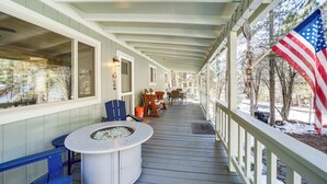 Eine überdachte Veranda mit Feuerstelle, Sitzgelegenheiten im Freien und einer amerikanischen Flagge.