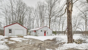 Two small, white buildings with red roofs, a dirt path, and a snowy landscape with leafless trees. - Riverfront Topsham Home ~ 28 Mi to Portland! (Topsham)