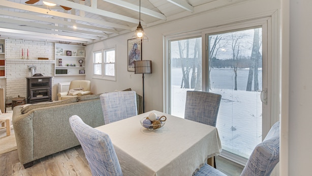 A dining area with a table, chairs, and a bowl of fruit. There is a window with blinds, a ceiling fan, and a wall-mounted light fixture. - Riverfront Topsham Home ~ 28 Mi to Portland! (Topsham)