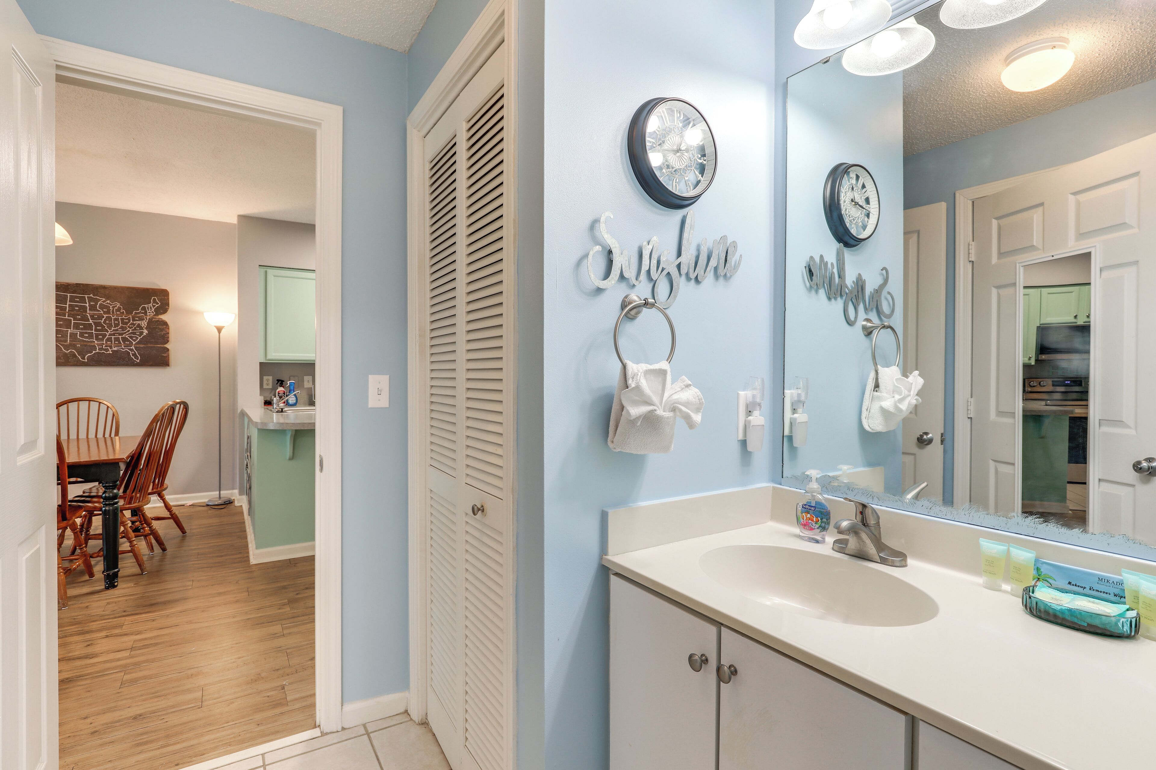 A bathroom with a sink, mirror, and towel rack.