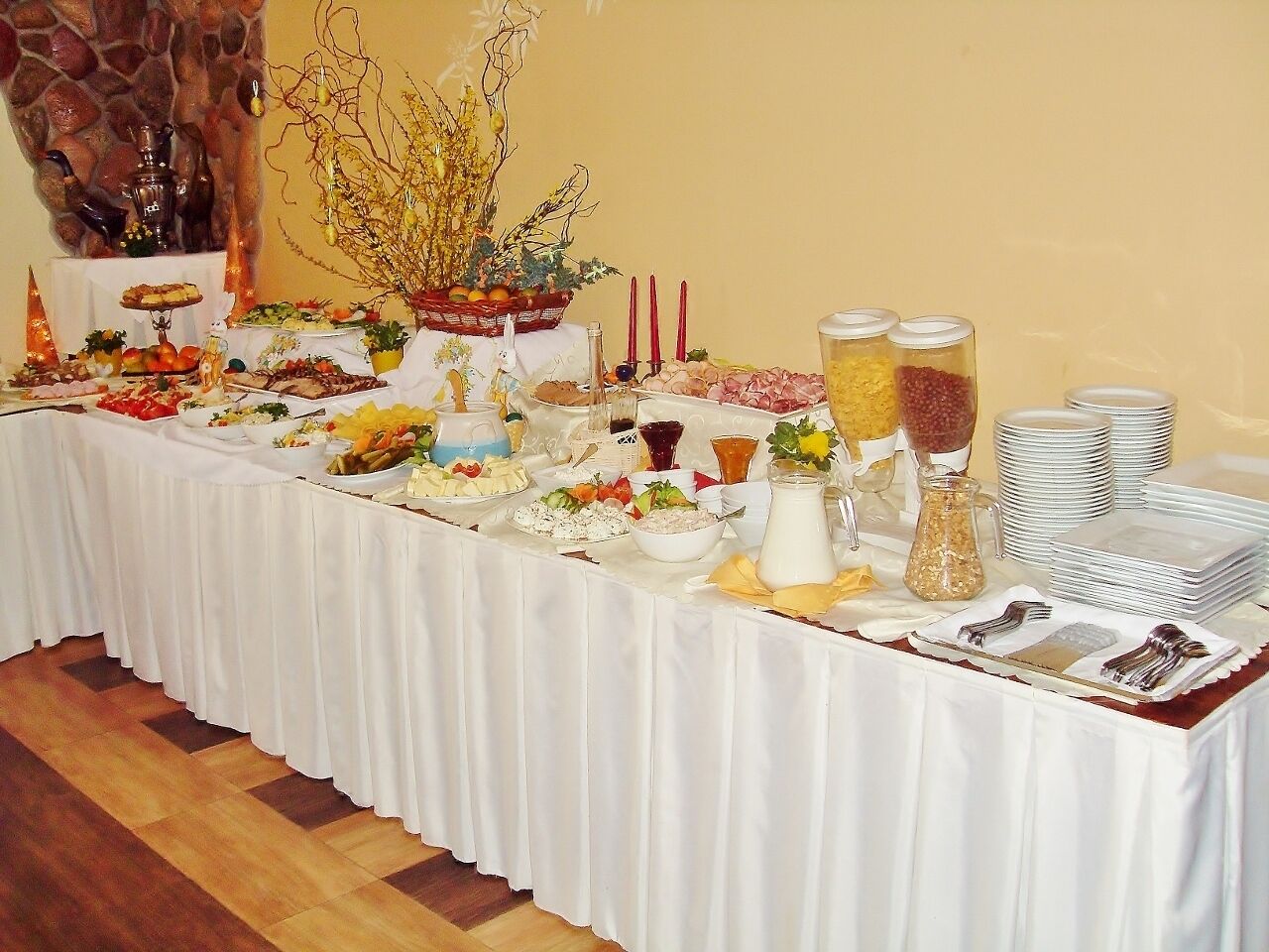 Una mesa de buffet con diferentes alimentos y salsas, con un fondo de pared de piedra.