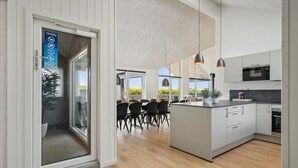 A modern kitchen with a central island, pendant lighting, and a view of the outdoors. - Nice home in Otterup with sauna (Otterup)