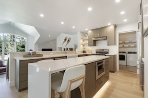 A modern kitchen with a large island, built-in appliances, and a view of the outdoors. - Legends 10 4br 4ba 4 Bedroom Townhouse by RedAwning (Copper Mountain)