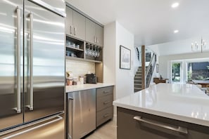 A modern kitchen with stainless steel appliances, a white countertop, and a staircase leading to another level. - Legends 10 4br 4ba 4 Bedroom Townhouse by RedAwning (Copper Mountain)