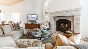 A cozy living room with a fireplace, comfortable seating, and a television.