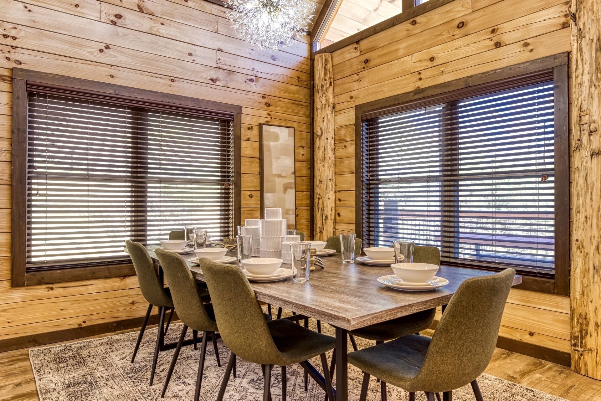 A wooden-paneled room with a dining table set for four, surrounded by chairs.