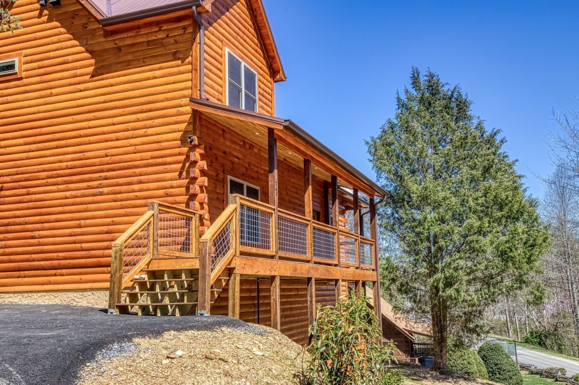 A log cabin with a wooden deck and a large window.