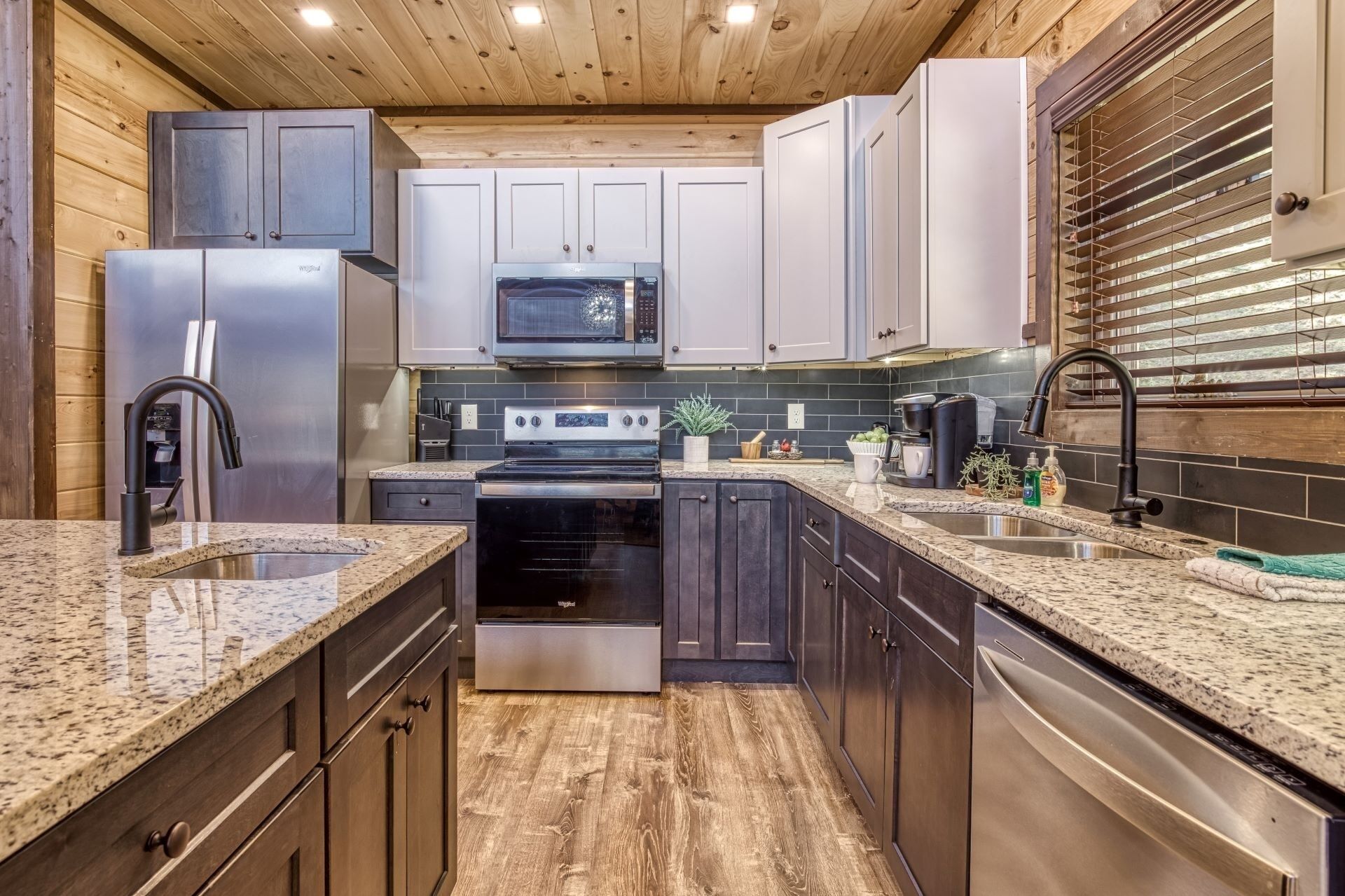 A modern kitchen with granite countertops, stainless steel appliances, and wooden cabinetry.