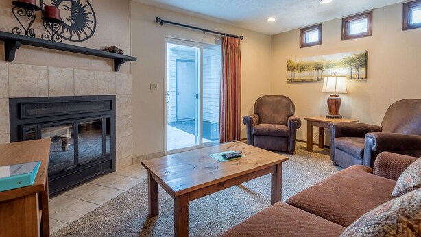A living room with a fireplace, a sofa set, a coffee table, and a painting on the wall.