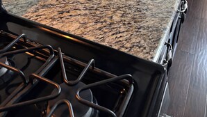 Une cuisine dotée d’un plan de travail en granit, d’une cuisinière et d’une pancarte de bienvenue.