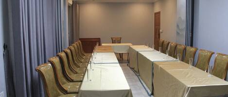 A conference room with a long table, chairs, and a door.