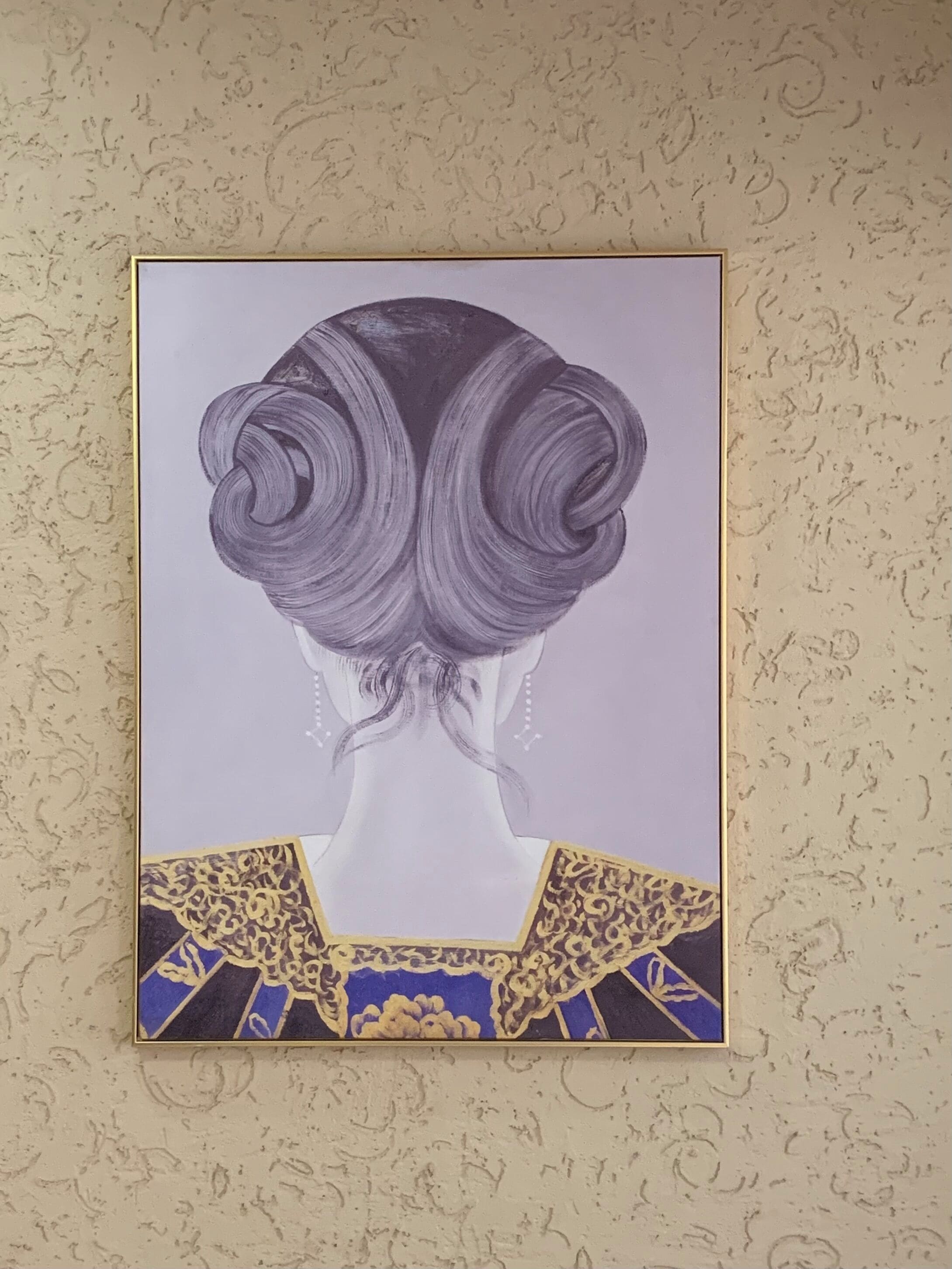Een lijstwerk met een afbeelding van de rug van een vrouw met een gedetailleerd kapsel en een sierlijke halslijn.