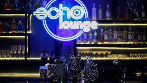 A bar with a neon sign reading "Echo Lounge" and shelves stocked with bottles. - Canwin Hotel (Accra)